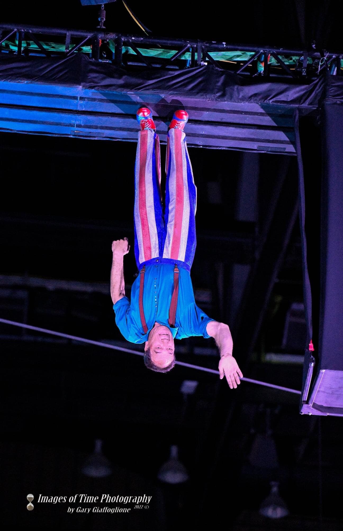 A performer walking upside down beneath the arena roof. Photo: Images of Time Photography by Gary Giallogione